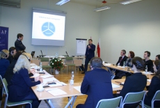 Uczestnicy seminarium siedzą w ławkach. Prowadzone są zajęcia.