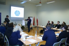 Uczestnicy seminarium siedzą w ławkach. Prowadzone są zajęcia.