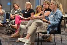 Uczestnicy siedzą na krzesłach i dyskutują.