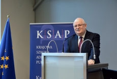 Dyrektor KSAP przemawia przy mównicy. W tle baner KSAP i flaga UE.