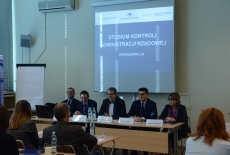 Dyrektor KSAP i pozostali wykładowcy siedzą przy stole i przemawiaja do uczestników