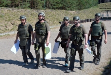 Słuchacze KSAP wracają ze strzelnicy. W rękach niosą papierowe tarcze.