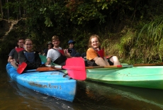 Słuchacze siedzą w kajakach