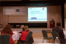 Sala konferencyjna. Uczestnicy siedzą tyłem do obiektywu.