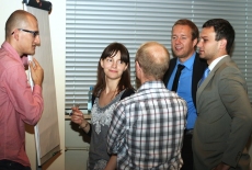 Grupa uczestników stoi przy flipcharcie i dyskutuje