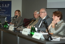 Osoby prowadzące siedzą przy stole prezydialnym