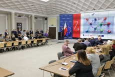 uczestnicy spotkania siedzą przy stołach