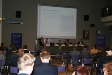 Widok sali i siedzących uczestników konferencji.