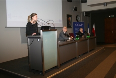 Uczestniczka konferencji przemawia przy mównicy do zebranych w sali.