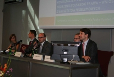 Osoby prowadzące konferencje siedzą przy stole prezydialnym