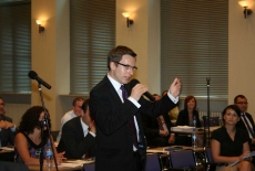 Jeden a Absolwentów mówi do mikrofonu między uczestnikami