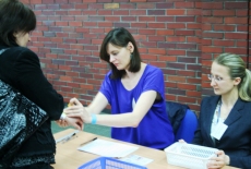 Uczestnicy egzaminu podchodzą do pań sprawdzających listy obecności