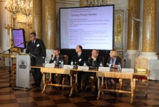 fot. Sebastian Szulfer/KSAP Pan stoi przy mównicy i mówi do mikrofonu obok siedzą prowadzący