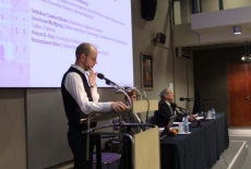 fot. Sebastian Szulfer/KSAP Pan stoi przy mównicy i przemawia z tyłu wyświetlana jest prezentacja