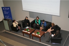 Zdjęcie sali i uczestników sesji warsztatowej. Uczestnicy siedzą w półokręgu przy stole prezydialnym, toczy się dyskusja.