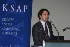 Marcin Sakowicz stoi przy mównicy.