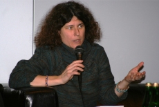 Uczestniczka sesji warsztatowej mówi przez mikrofon siedząc.