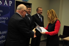 Dyrktor Jan Pastwa wręcza dyplom. Na drugim planie widać Wiceprezesa NIK Wojciecha Kutyłę i przedstawiciela KPRM Tomasza Bolka.