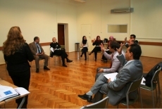 Uczestnicy szkolenia siedzą na krzesłach w okręgu, po środku prowadzący