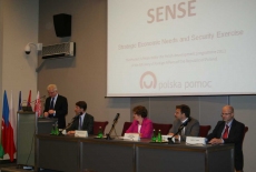 Dyrektor KSAP Jacek Czaputowicz stoi na mównicy i przemawia obok siedzą prowadzący szkolenie