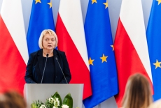 przemawia dyrektor KSAP, w tle polskie i unijne flagi