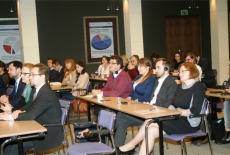 Przybyli goście siedzą w ławkach na auli KSAP.