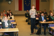 Uczestniczka spotkania zadaje pytanie stojąc pośród siedzących słuchaczy.