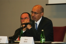 Francuski Sekretarz Stanu Harlem Désir mowi do mikrofonu. Za nim siedzi wicedyrektor szkoły Marek Haliniak