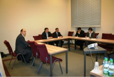 Uczestnicy wizyty siedzą przy stole.