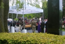 Na trumnę kładziona jest flaga Polski przez żołnierzy.