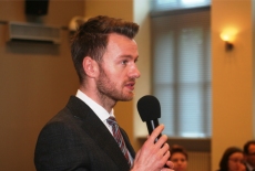 Uczestnik wykładu stojąc zadaje pytanie do mikrofonu.