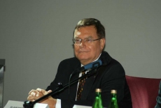 Pan siedzi przy stole prezydialnym