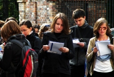 Słuchacze stoją z notatkami.