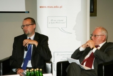 Dwóch uczestników panelu dyskusyjnego siedzi na fotelach