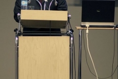 Pan stoi  przy mównicy i przemawia