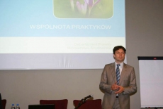 Dr Marcin Sakowicz przemawia w tle prezentacja