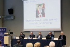 Paneliści siedzą przy stole prezydialnym