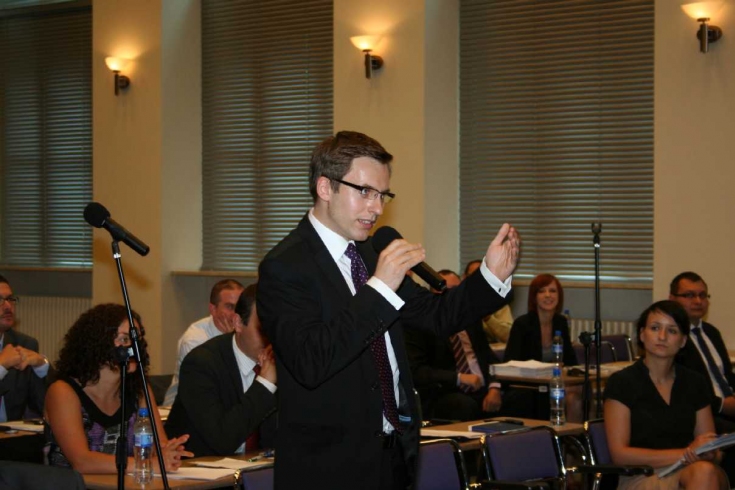 Jeden a Absolwentów mówi do mikrofonu między uczestnikami