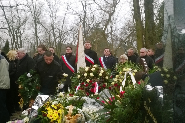 Na cmentarzu poczet szandarowy KSAP stoi przed grobem.