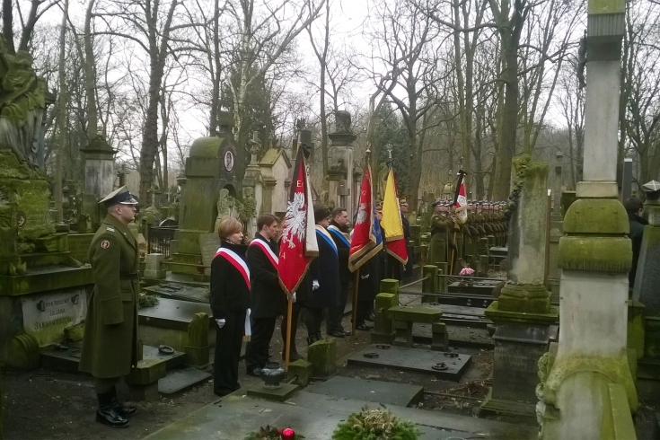 Poczet sztandarowy KSAP stoi na cmentarzu.