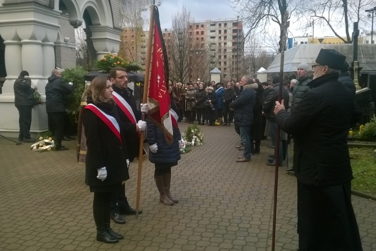 Poczet sztandarowy KSAP stoi na cmentarzu na przeciwko księdza
